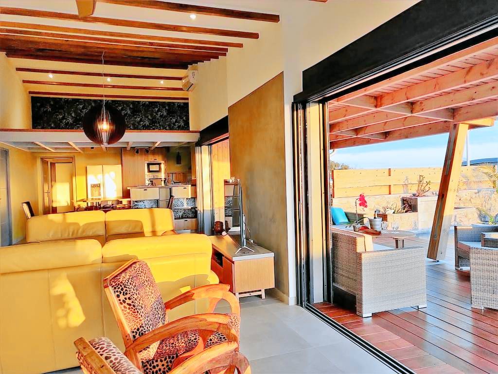 Séjour ouvert de la Villa Kiwenna avec baies vitrées donnant sur la terrasse